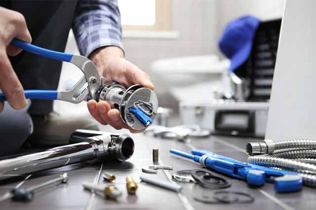 repairing showerhead using tools such as bolt cutters and spanners.